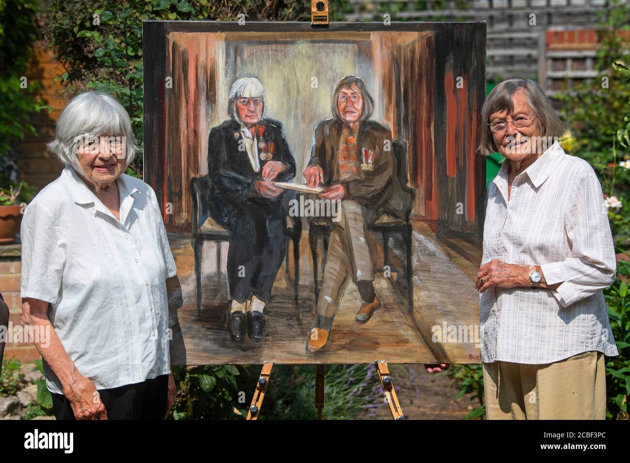 Patricia Davie et Jean Argles (L-R), les dernières sœurs vivantes à avoir tous deux signé la Loi sur les secrets officiels pendant la Seconde Guerre mondiale, dévoilent leur portrait de Dan Llywelyn Hall, à l'ouest de Londres, en prévision de la Journée VJ. Banque D'Images