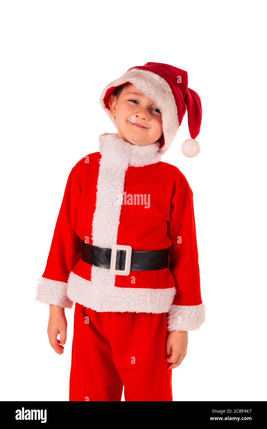 Portrait d'un petit garçon mignon (4 ans) debout en souriant portant un costume rouge du Père Noël avec un chapeau de Père Noël. Thème Noël et vacances isola Banque D'Images