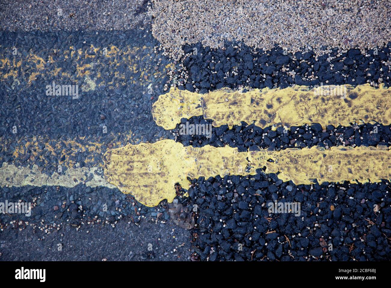 Un gros plan de deux lignes jaunes sur les routes en bordure de trottoir Banque D'Images