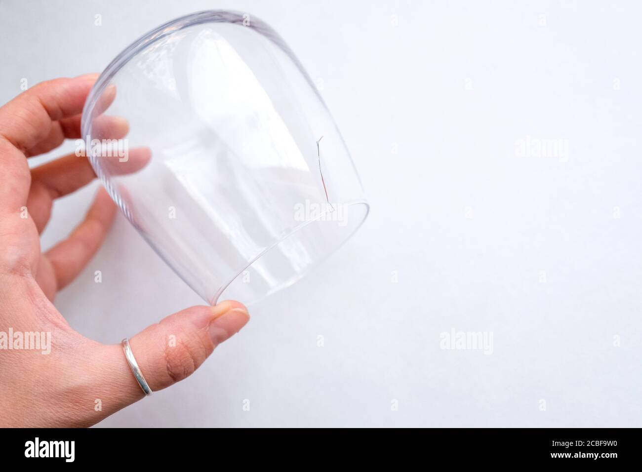 Fissure dans la vitre. Tient un verre transparent dans sa main. Vue de dessus. Banque D'Images