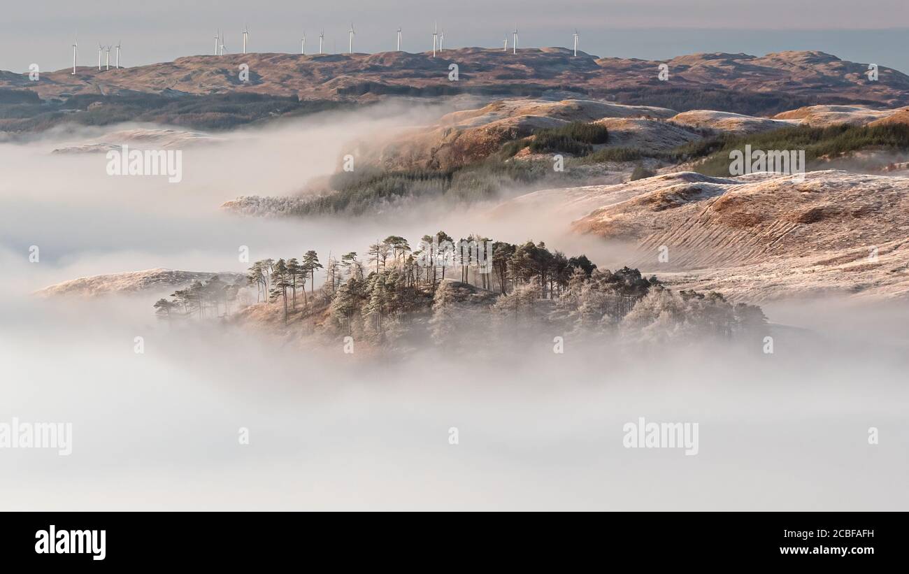 Vue panoramique sur une belle inversion de nuages, observée au lever du soleil depuis les pentes de Ben Cruchan, alors que les collines au-dessus du Loch Awe émergent de la mer de clo Banque D'Images