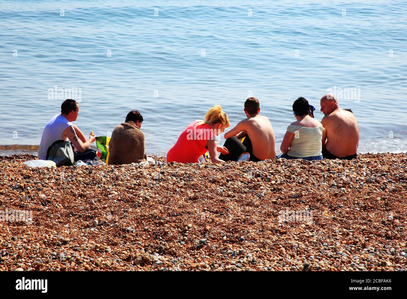 Hastings, Royaume-Uni, 28 avril 2011 : UN groupe de vacanciers qui bronzer sur une plage de galets dans Hastings East Sussex est un voyage populaire de Banque D'Images
