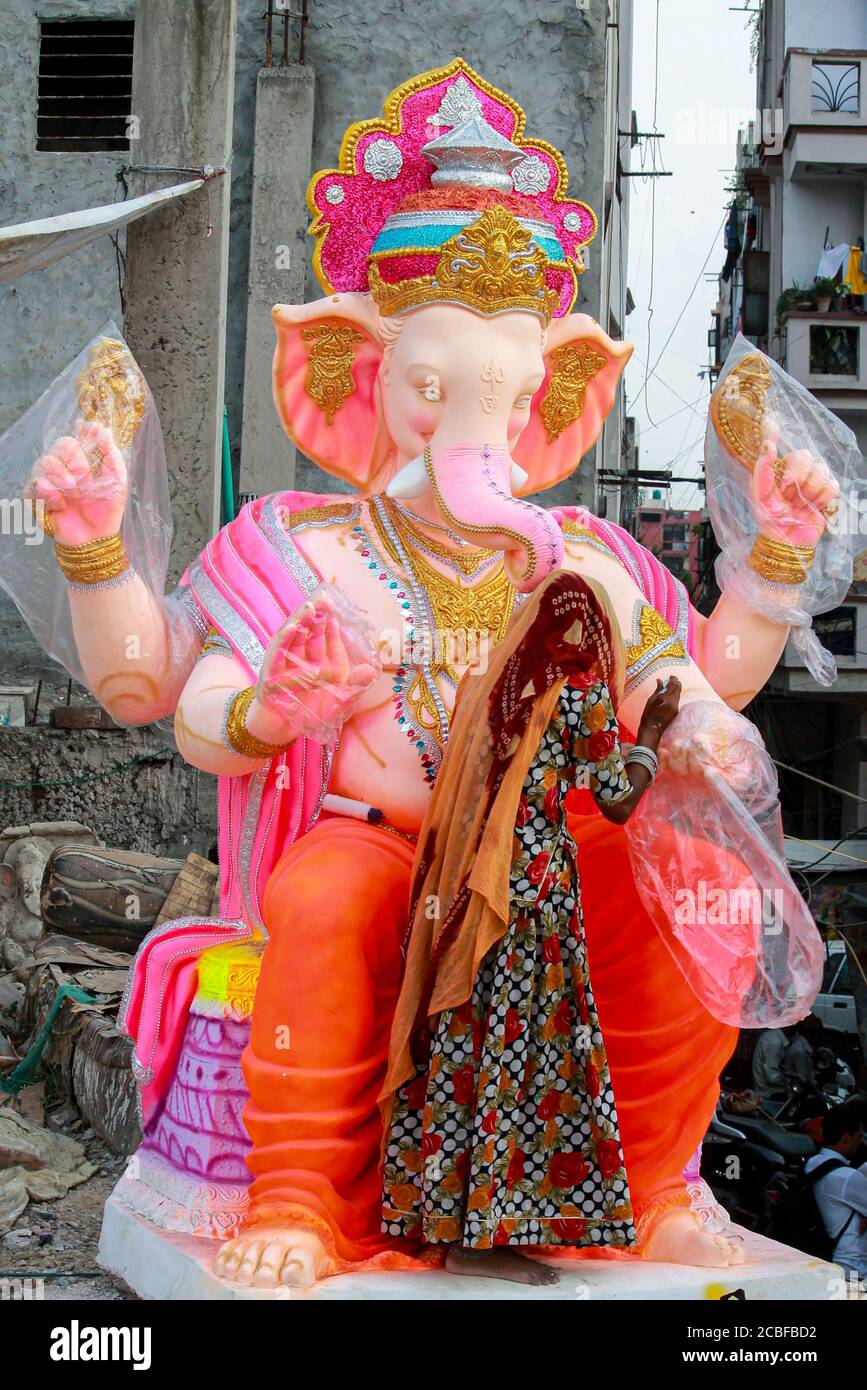 Artistes locaux de bord de route décorant la statue de dieu Ganesha en utilisant Plaster de peris pour la préparation de l'occasion religieuse ganesh chaturthi Banque D'Images