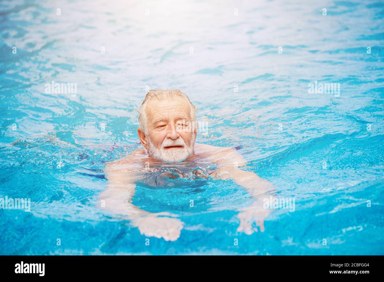 Caucasiens sain aîné natation à la piscine pour se détendre en vacances d'été Banque D'Images