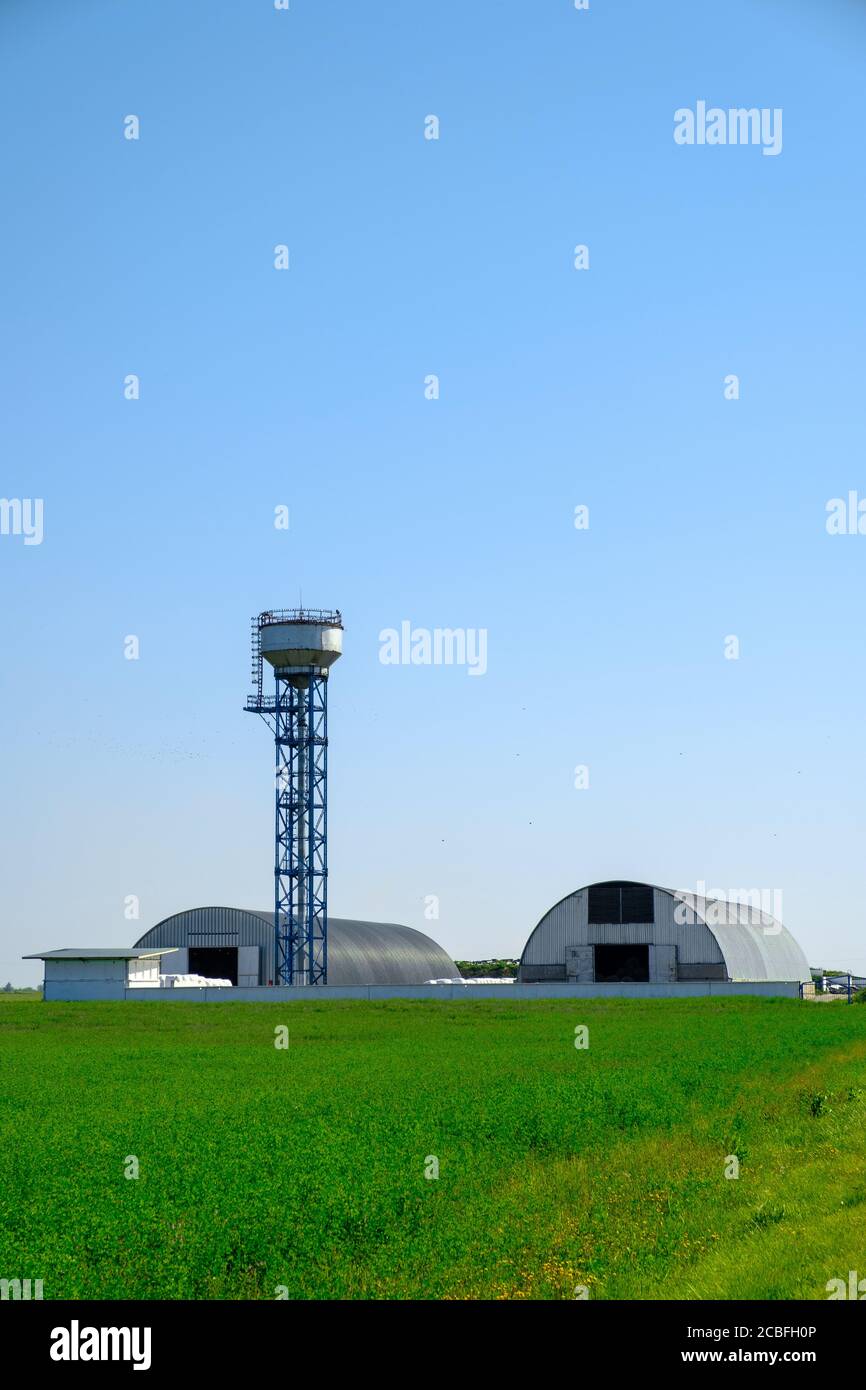 Hangars voûtés et tour. Grande capacité de stockage pour les cultures agricoles. Concept d'agro-industrie. Banque D'Images