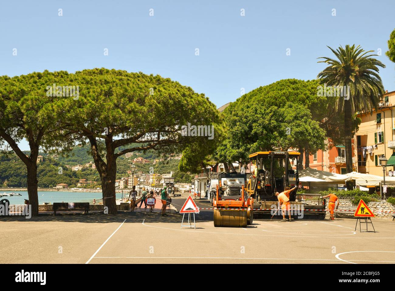 Resurfaçage de la route sur la promenade du front de mer avec les travailleurs du conseil au travail et les touristes marchant en été, Lerici, la Spezia, Ligurie, Italie Banque D'Images