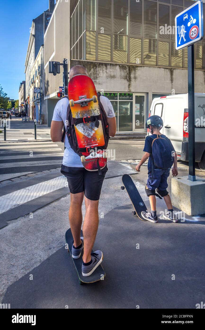 Père et fils skate sur leur chemin de retour - Nantes, Loire-Atlantique, France. Banque D'Images
