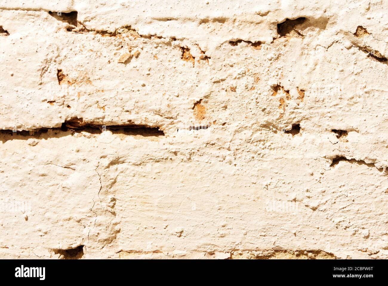 Texture d'un vieux mur de briques peint avec peinture blanche gros plan. Banque D'Images