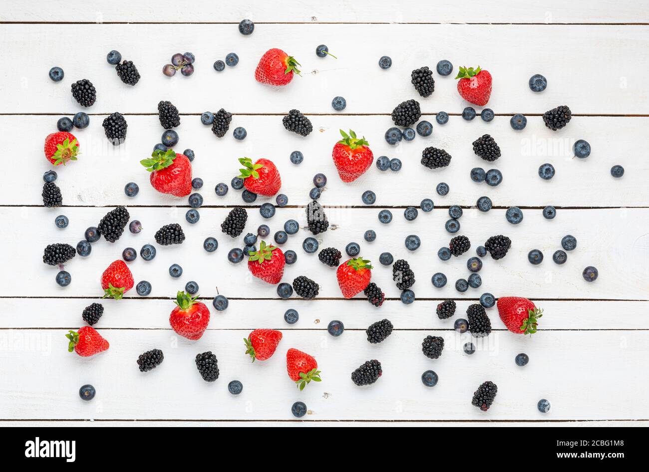 Fraises, bleuets et mûres sur bois blanc. Banque D'Images