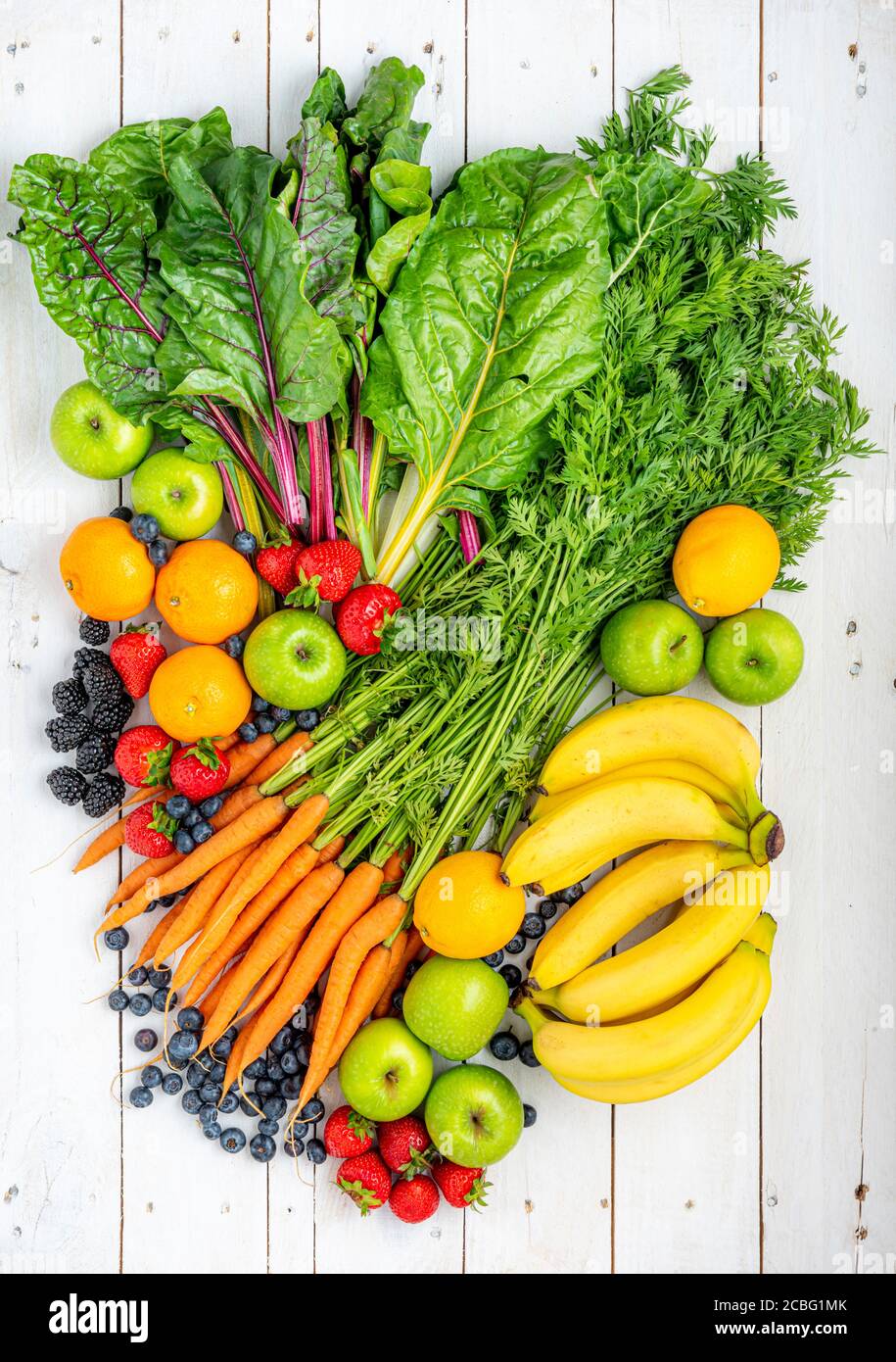 Assortiment de fruits et légumes frais sur bois blanc. Banque D'Images