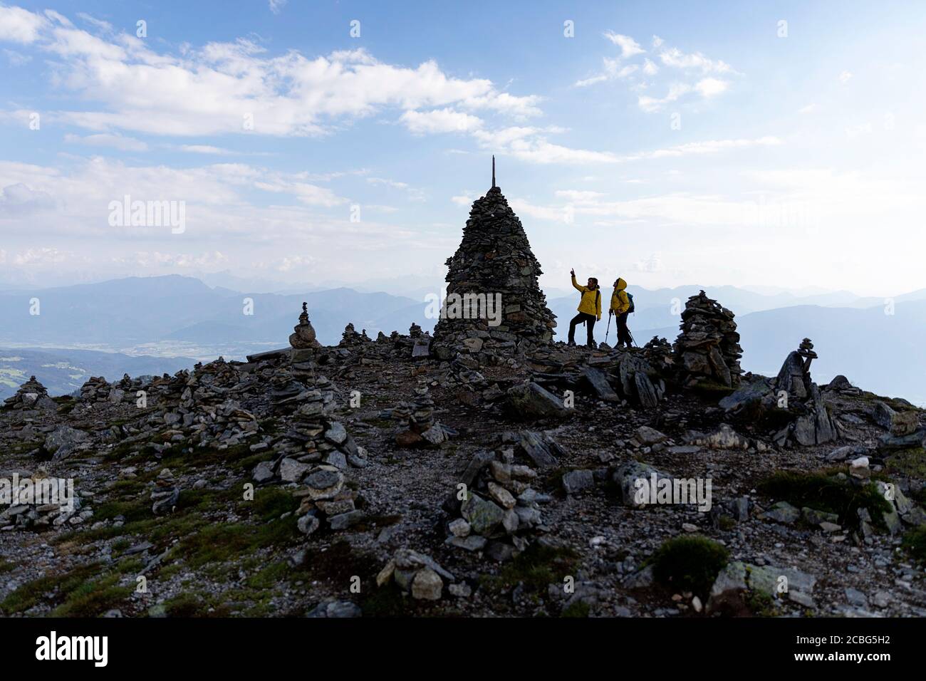 Mère et ainsi de suite avec debout par des tours en pierre au coucher du soleil sur Love Trail, Granattor, croix de sommet, Lammersdorf montagne, Nock montagnes, Carinthie, Autriche Banque D'Images