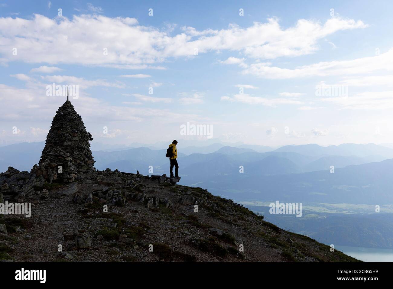 Femme avec debout près des tours de pierre au coucher du soleil sur Love Trail, Granattor, croix de sommet, Lammersdorf montagne, Nock montagnes, Carinthie, Autriche Banque D'Images