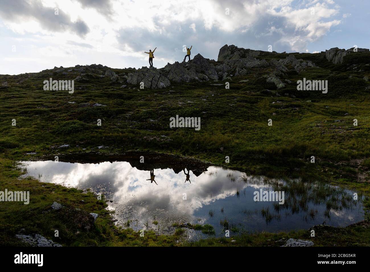 Mère et fils ayant un bon moment à l'extérieur, levant les mains sur les rochers par petit lac sur Granattor, Lammersdorf montagne, Autriche Banque D'Images