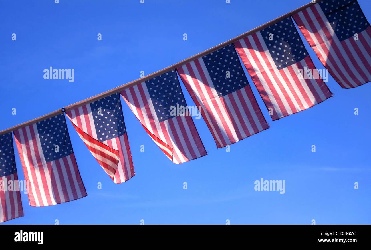 Les drapeaux américains flottent dans la brise contre un ciel bleu Banque D'Images