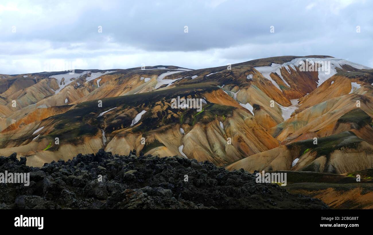 Les montagnes peintes de Landmannalaugar sous les nuages de Stormcloud avec une Lava Champ dans le premier plan Banque D'Images