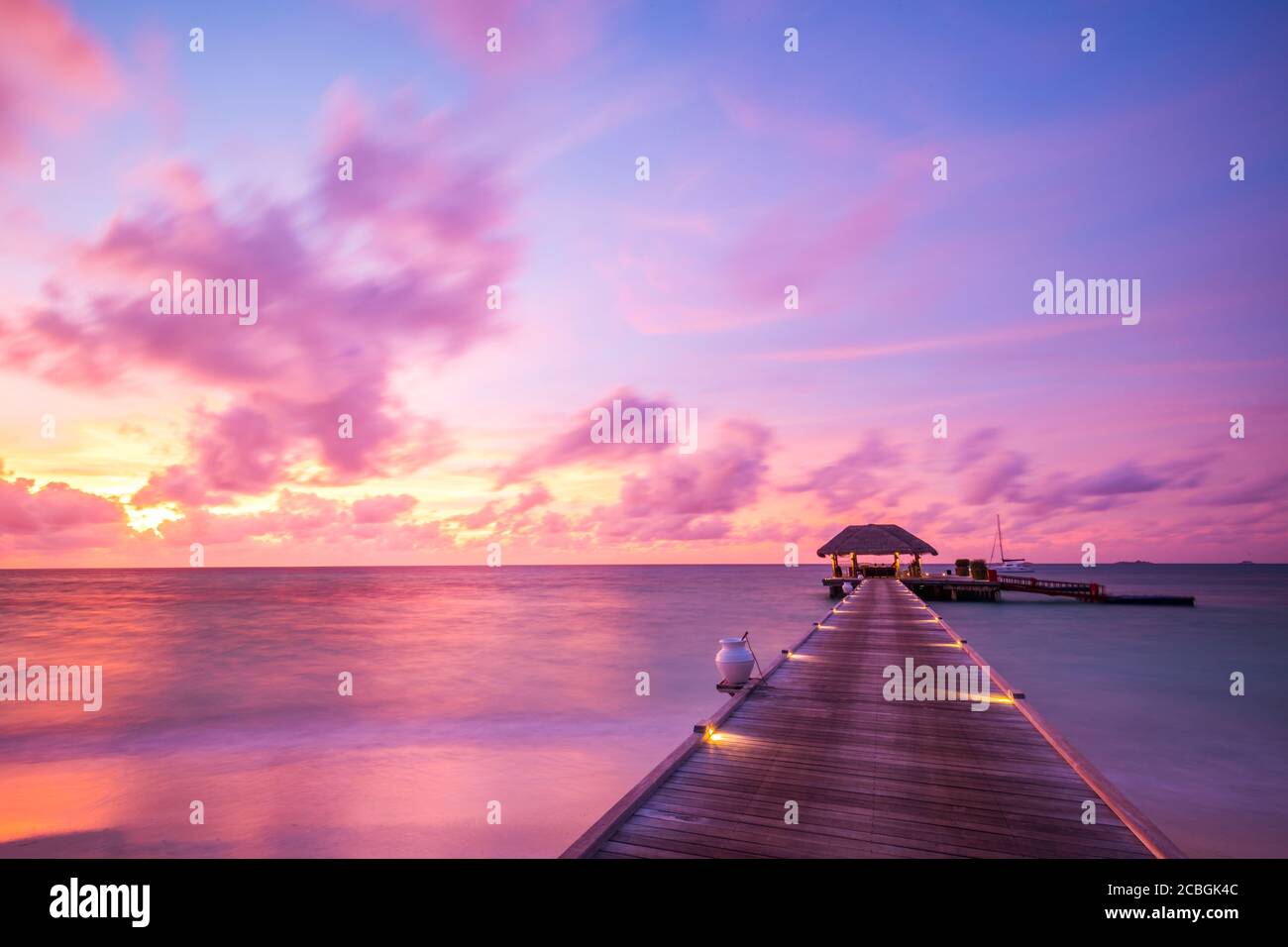 Coucher de soleil sur l'île des Maldives. Station balnéaire de bungalows d'eau à la plage des îles. Océan Indien, Maldives. Magnifique coucher de soleil, station de luxe et ciel coloré. Banque D'Images