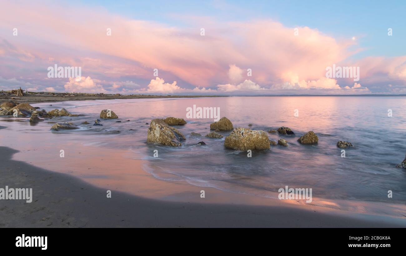 Ligne de rochers le long d'Ocean Beach avec Pink Sunset Sky Banque D'Images