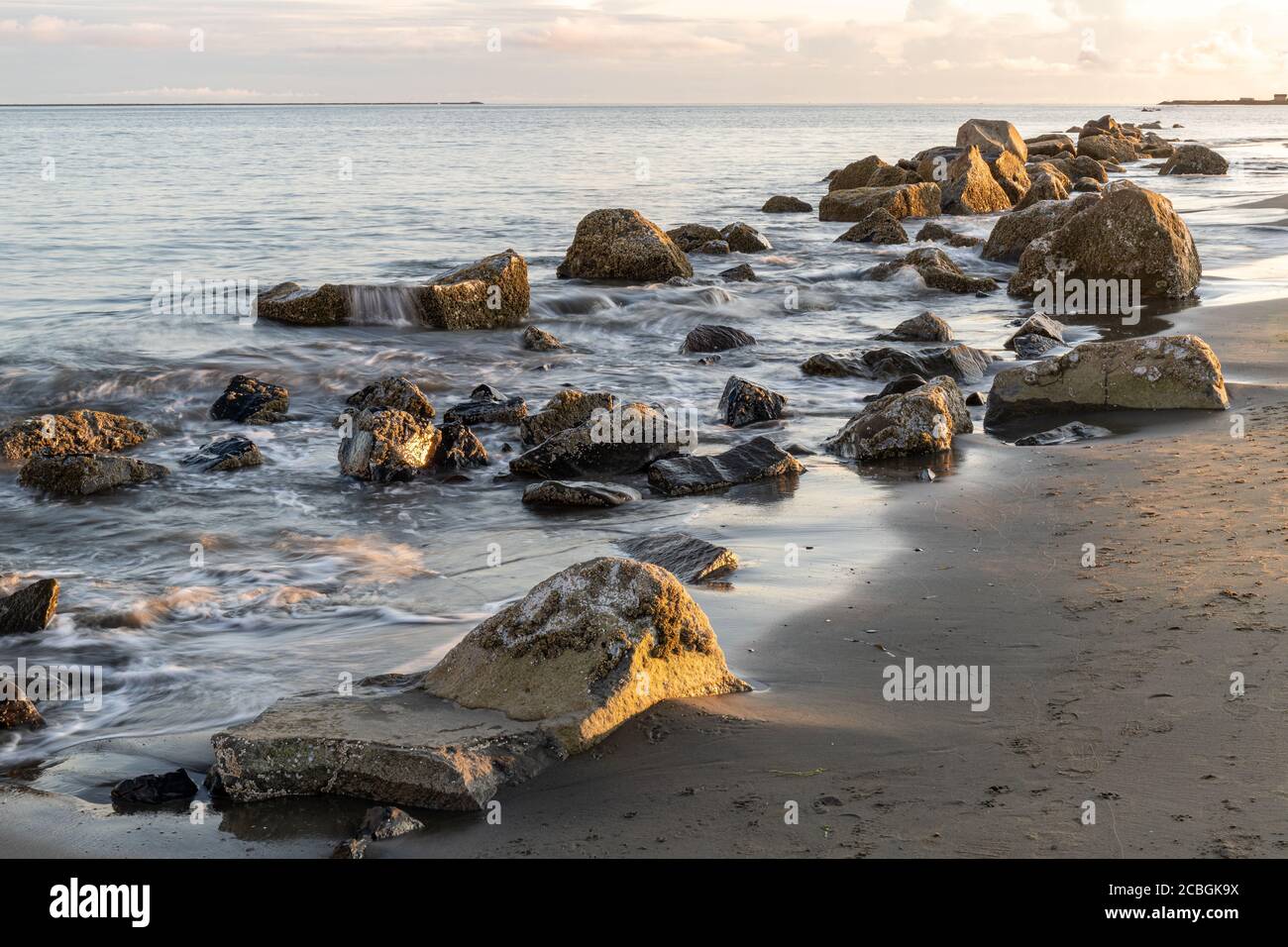 Line of Rocks le long d'Ocean Beach au coucher du soleil Banque D'Images