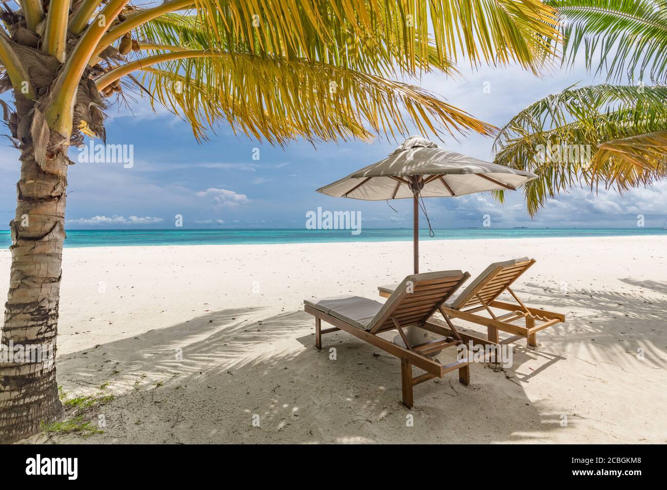 Belle plage tropicale. Sable blanc et chaises de coco Palms, tourisme de voyage parapluie, paysage de plage incroyable. Vacances ou vacances de luxe sur l'île Banque D'Images