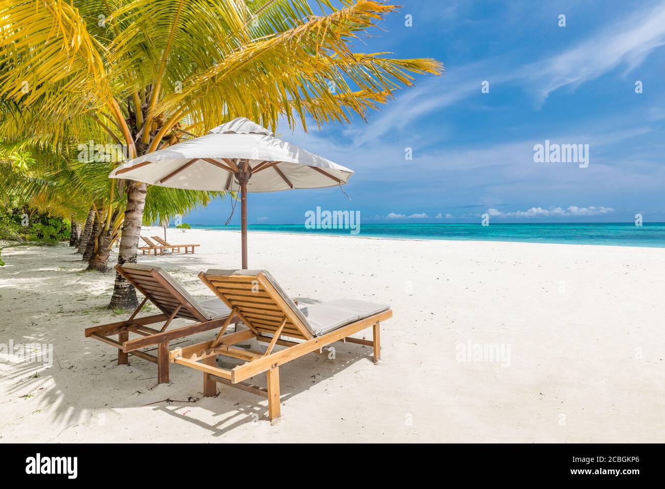 Belle plage tropicale. Sable blanc et chaises de coco Palms, tourisme de voyage parapluie, paysage de plage incroyable. Vacances ou vacances de luxe sur l'île Banque D'Images