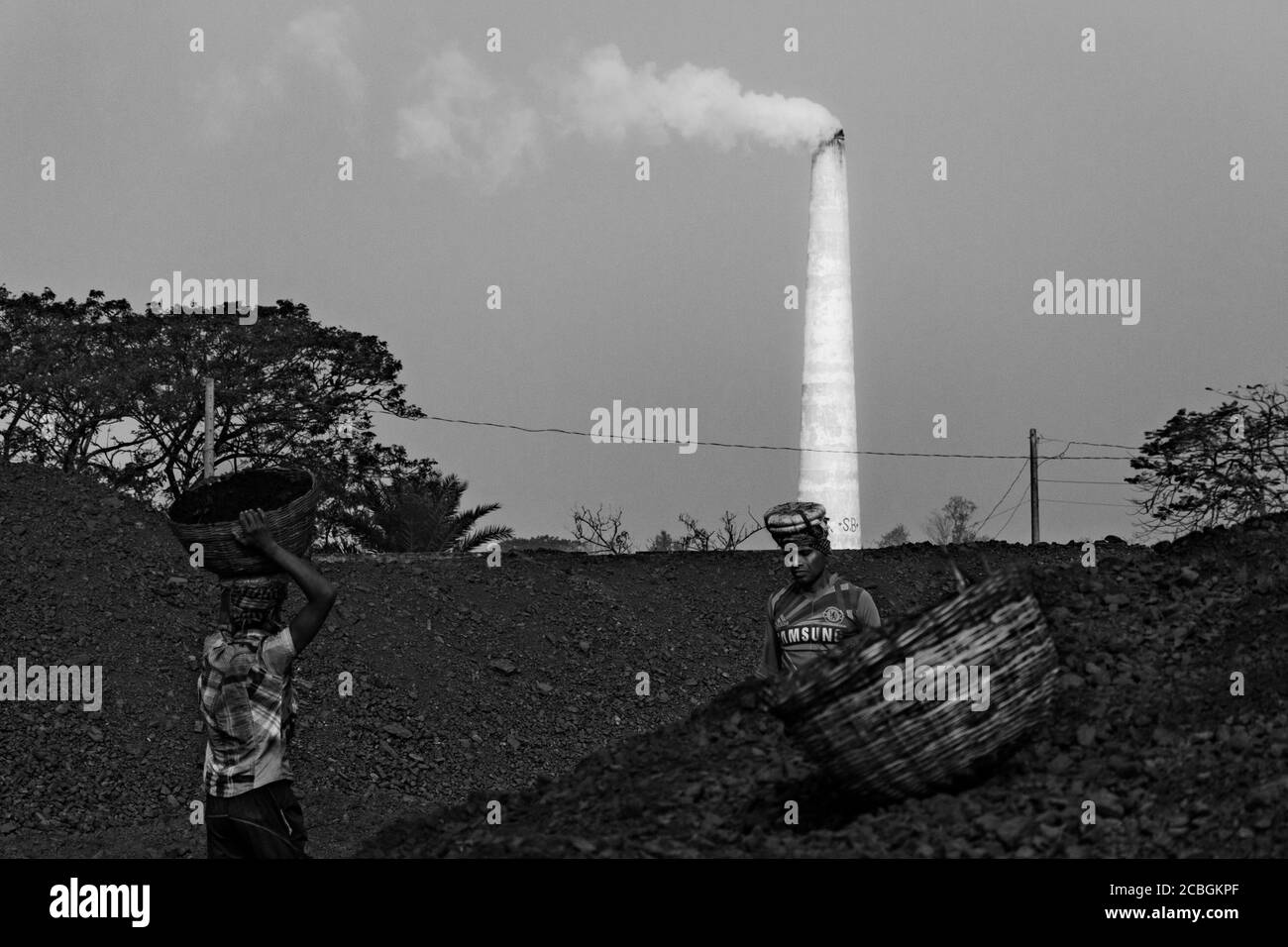 Les laboureurs déchargent le charbon d'un cargo à Khulna, au Bangladesh. L'industrie de la brique est l'un des principaux consommateurs de ce charbon. Banque D'Images