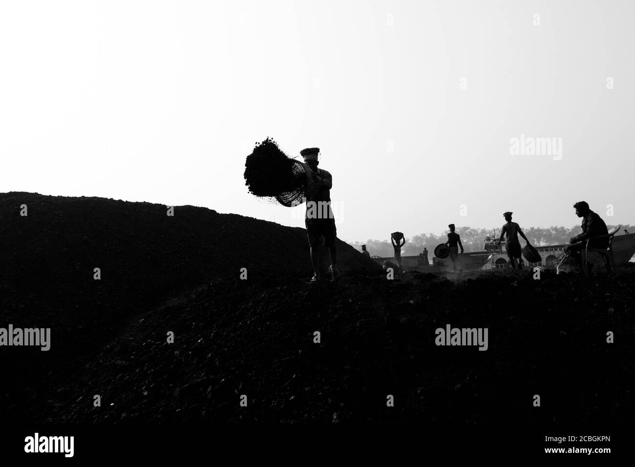 Les laboureurs déchargent le charbon d'un cargo à Khulna, au Bangladesh. L'industrie de la brique est l'un des principaux consommateurs de ce charbon. Banque D'Images