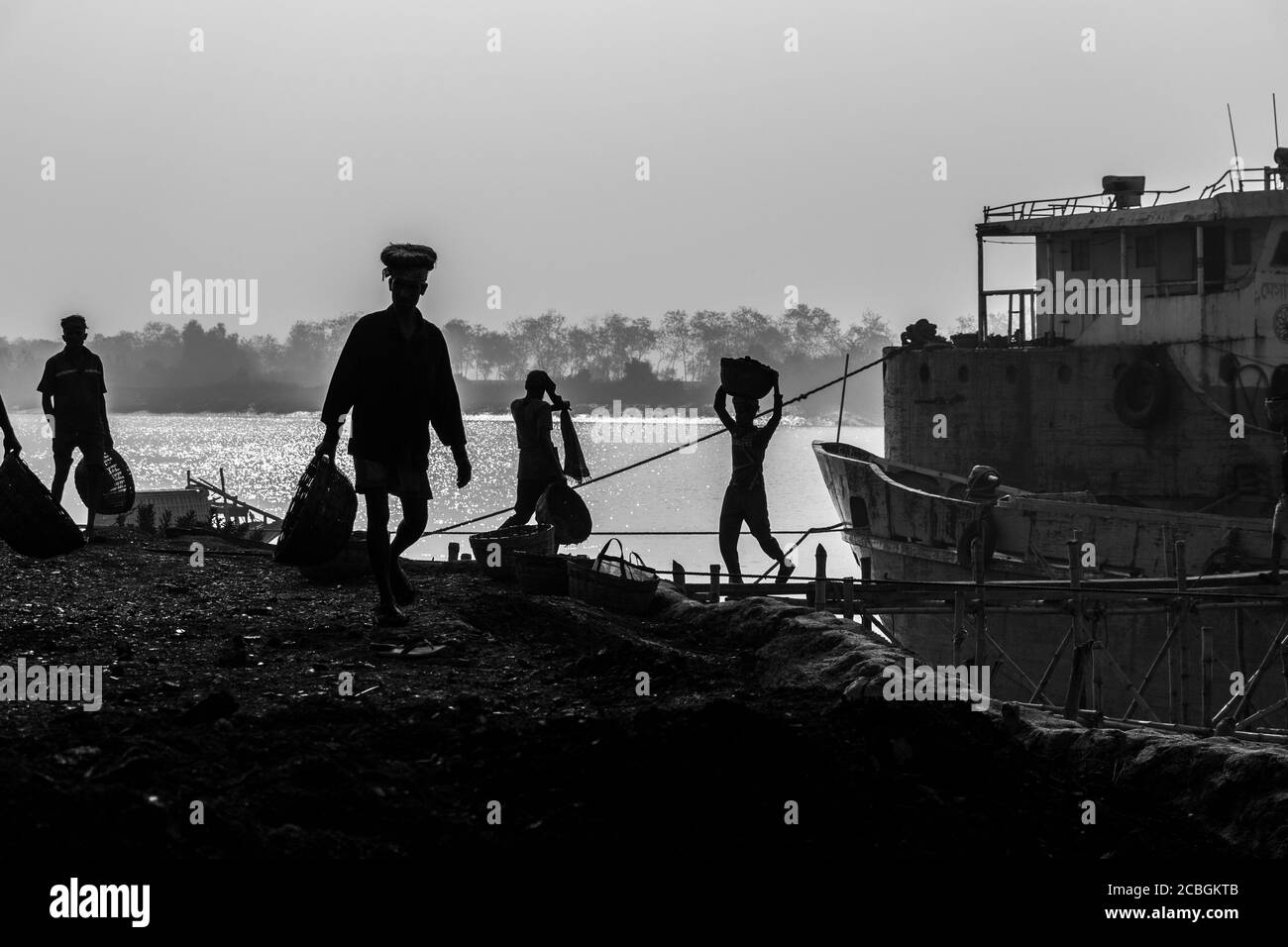 Les laboureurs déchargent le charbon d'un cargo à Khulna, au Bangladesh. L'industrie de la brique est l'un des principaux consommateurs de ce charbon. Banque D'Images