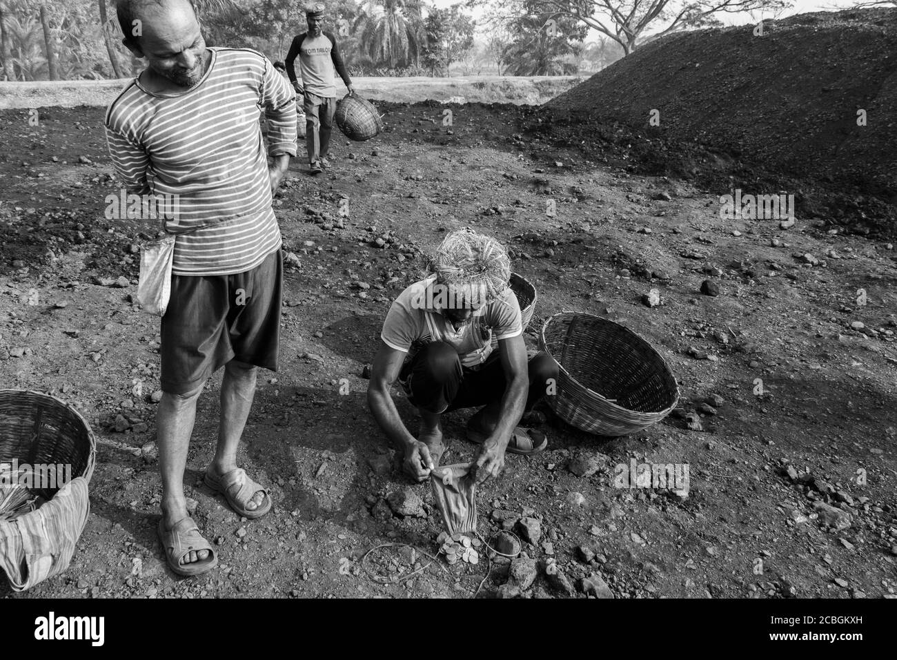 Les laboureurs déchargent le charbon d'un cargo à Khulna, au Bangladesh. L'industrie de la brique est l'un des principaux consommateurs de ce charbon. Banque D'Images