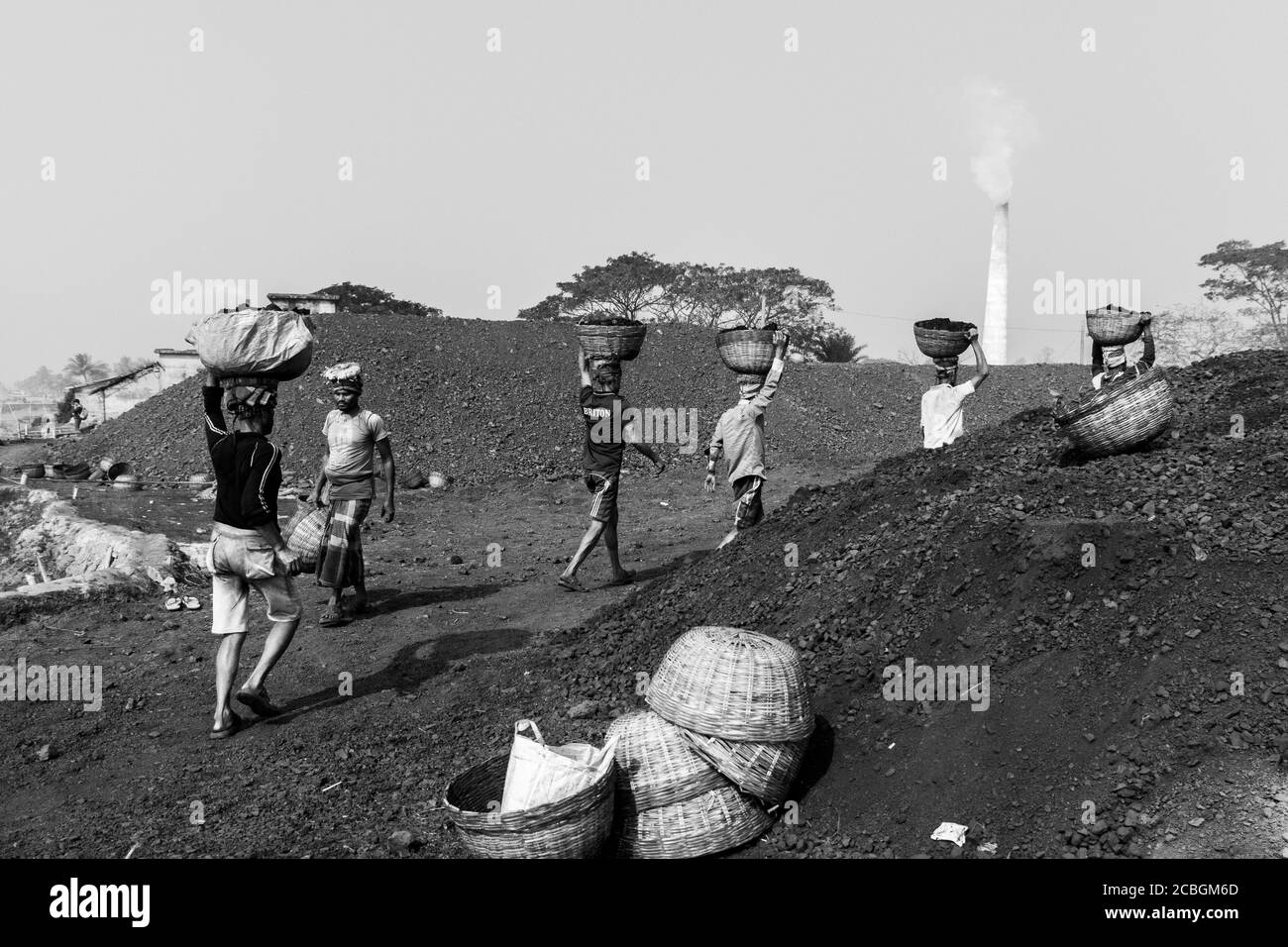 Les laboureurs déchargent le charbon d'un cargo à Khulna, au Bangladesh. L'industrie de la brique est l'un des principaux consommateurs de ce charbon. Banque D'Images