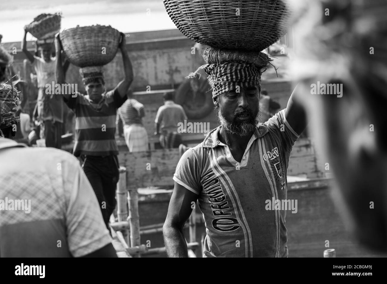 Les laboureurs déchargent le charbon d'un cargo à Khulna, au Bangladesh. L'industrie de la brique est l'un des principaux consommateurs de ce charbon. Banque D'Images