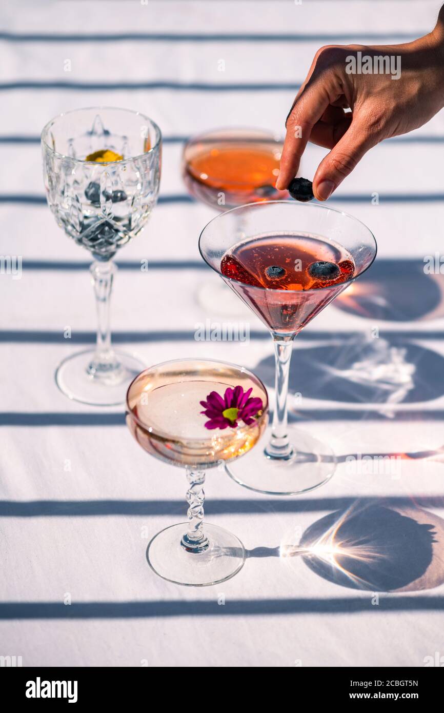 Boissons alcoolisées colorées, cocktails de fruits sur fond blanc lors d'une chaude journée d'été sous le soleil Banque D'Images