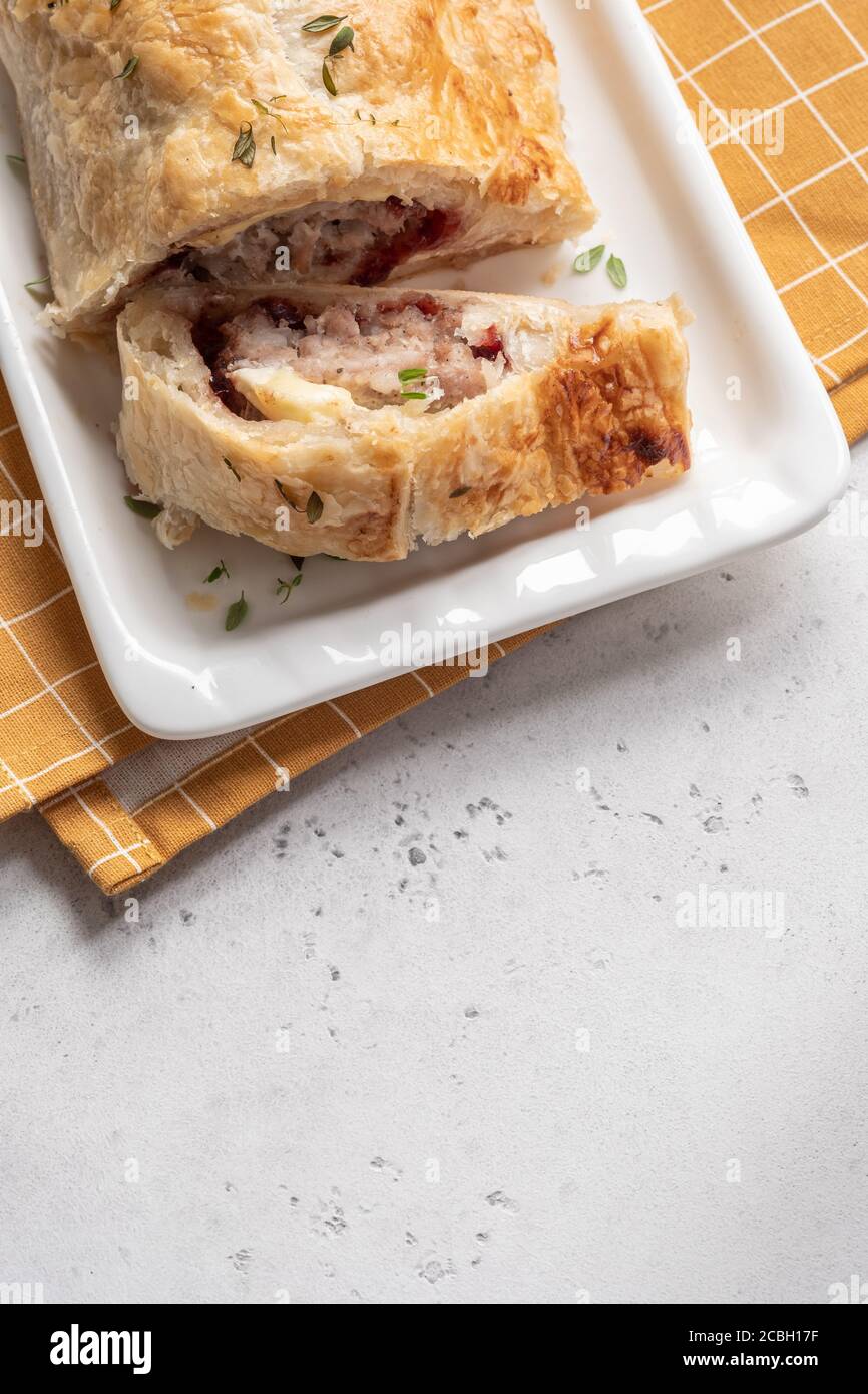Petits pains de saucisse de dinde de porc cuits au fromage de brie et aux canneberges sauce dans une pâte feuilletée Banque D'Images