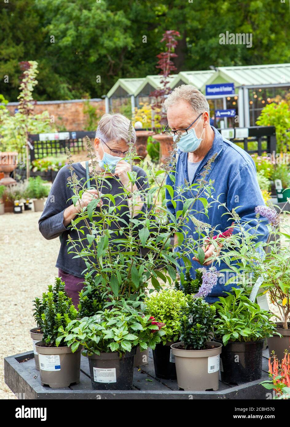 Couple homme et femme shopping à l'extérieur dans un centre de jardin port de masques couvrant Banque D'Images