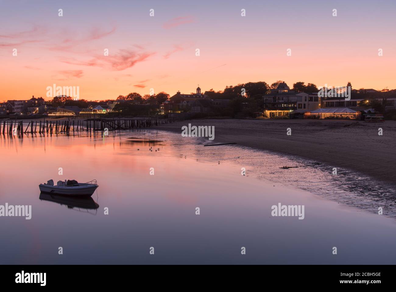 Photo d'une plage de sable déserte avec un bateau ancré en premier plan au crépuscule Banque D'Images