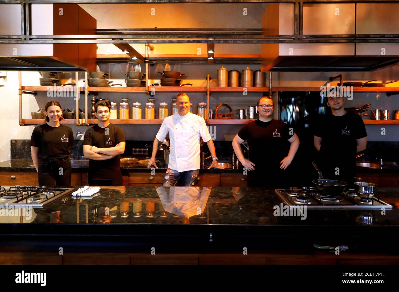 Istanbul, Turquie. 12 août 2020. Michael Riemenschneider (C), le chef allemand étoilé au guide Michelin, pose avec des membres du personnel dans son restaurant d'Istanbul, Turquie, le 12 août 2020. Après avoir passé près de quatre mois à la maison pendant les jours de quarantaine, le chef a ouvert les yeux sur un monde tout à fait nouveau où de nombreuses personnes ont commencé à aller à la région, à faire du shopping dans un magasin local, un boucher local, et à manger les produits des fermiers locaux. Credit: Osman Orsal/Xinhua/Alay Live News Banque D'Images