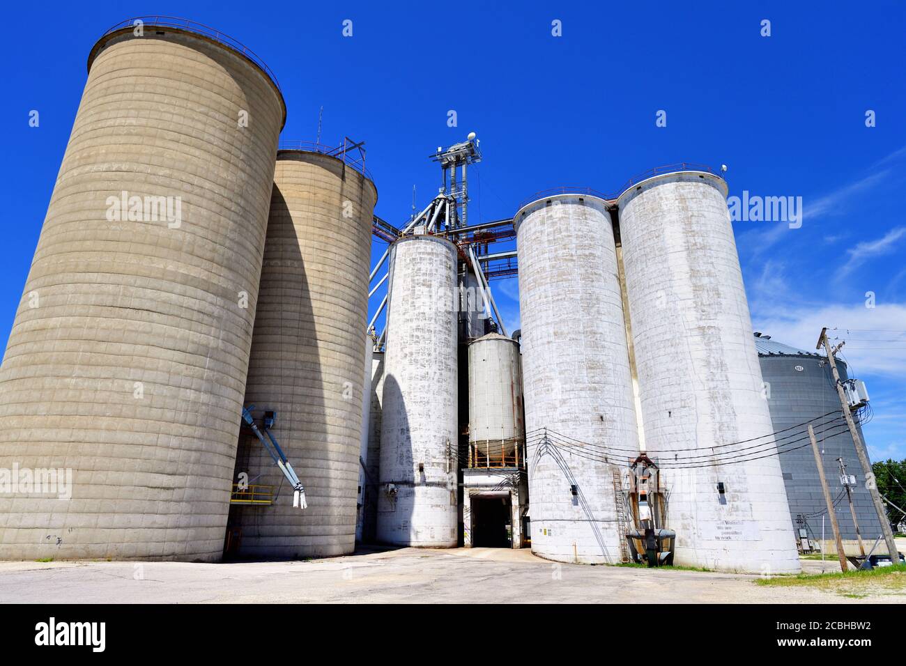 Watseka, Illinois, États-Unis. Les silos à grains anciens chevauchent une ligne principale de chemin de fer à double voie dans une petite communauté du centre-nord de l'Illinois. Banque D'Images
