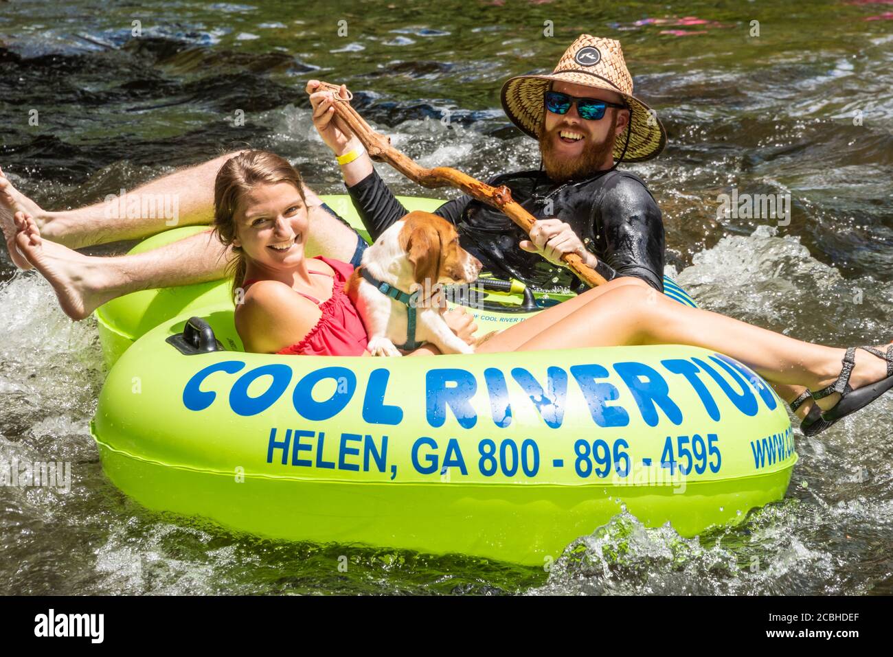 Couple heureux tubing sur la rivière Chattahoochee avec leur chien dans les montagnes de la Géorgie du Nord à Helen, Géorgie. (ÉTATS-UNIS) Banque D'Images