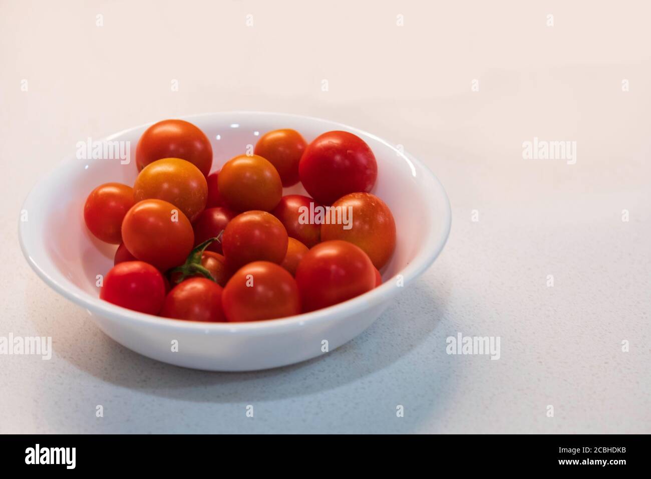 Petit bol blanc rempli de tomates cerises mûres, « Husky Cherry Red » cultivé à la maison. ÉTATS-UNIS. Banque D'Images