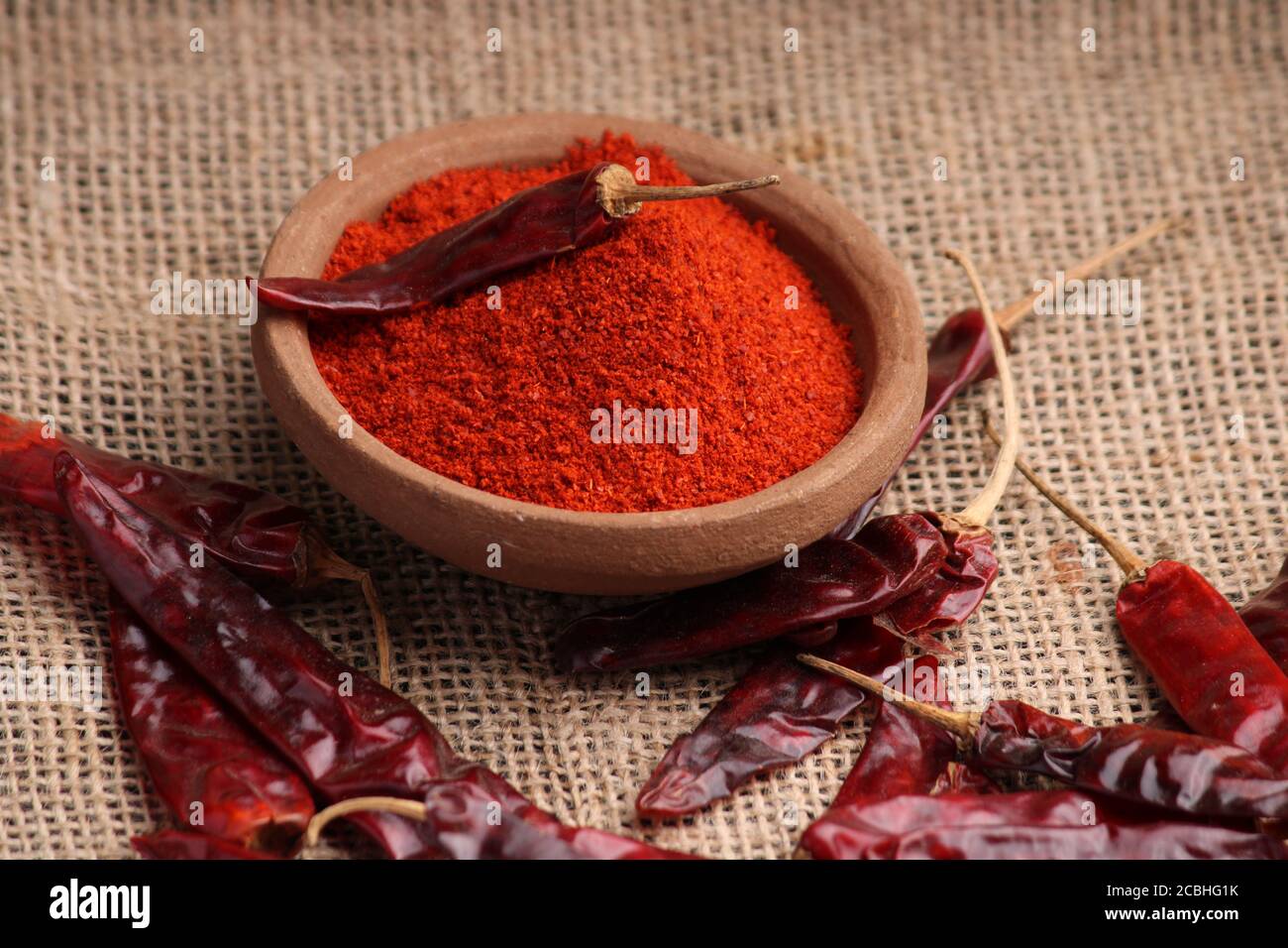 poudre de piment rouge avec piments rouges séchés. dans un bol en terre. Banque D'Images