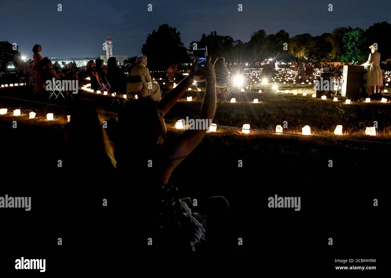 Berlin, Allemagne. 13 août 2020. Le public suit la performance dans le labyrinthe de lumières à la production de la pièce "le Grand Voyage" par le théâtre ANU sur Tempelhofer Feld. Dans chaque cas, 50 personnes peuvent marcher à travers le cours, qui est illuminé par 3,500 bougies, à des intervalles de 15 minutes sur un total de neuf tours de jeu. Credit: Britta Pedersen/dpa-Zentralbild/dpa/Alay Live News Banque D'Images