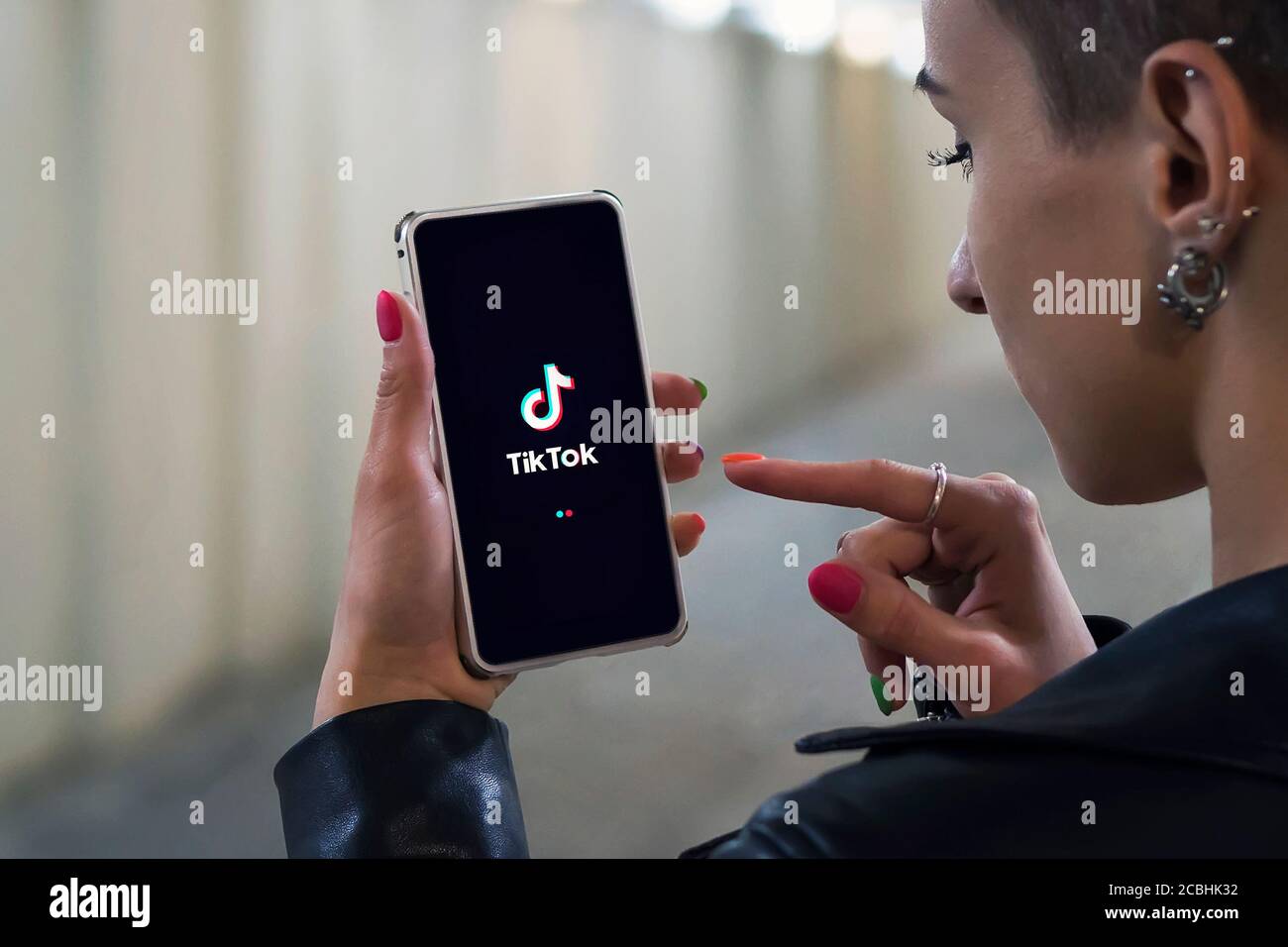 Femmes tenant le téléphone avec le logo TikTok à l'écran. Tik Tok est une application permettant de créer et de partager des vidéos Banque D'Images