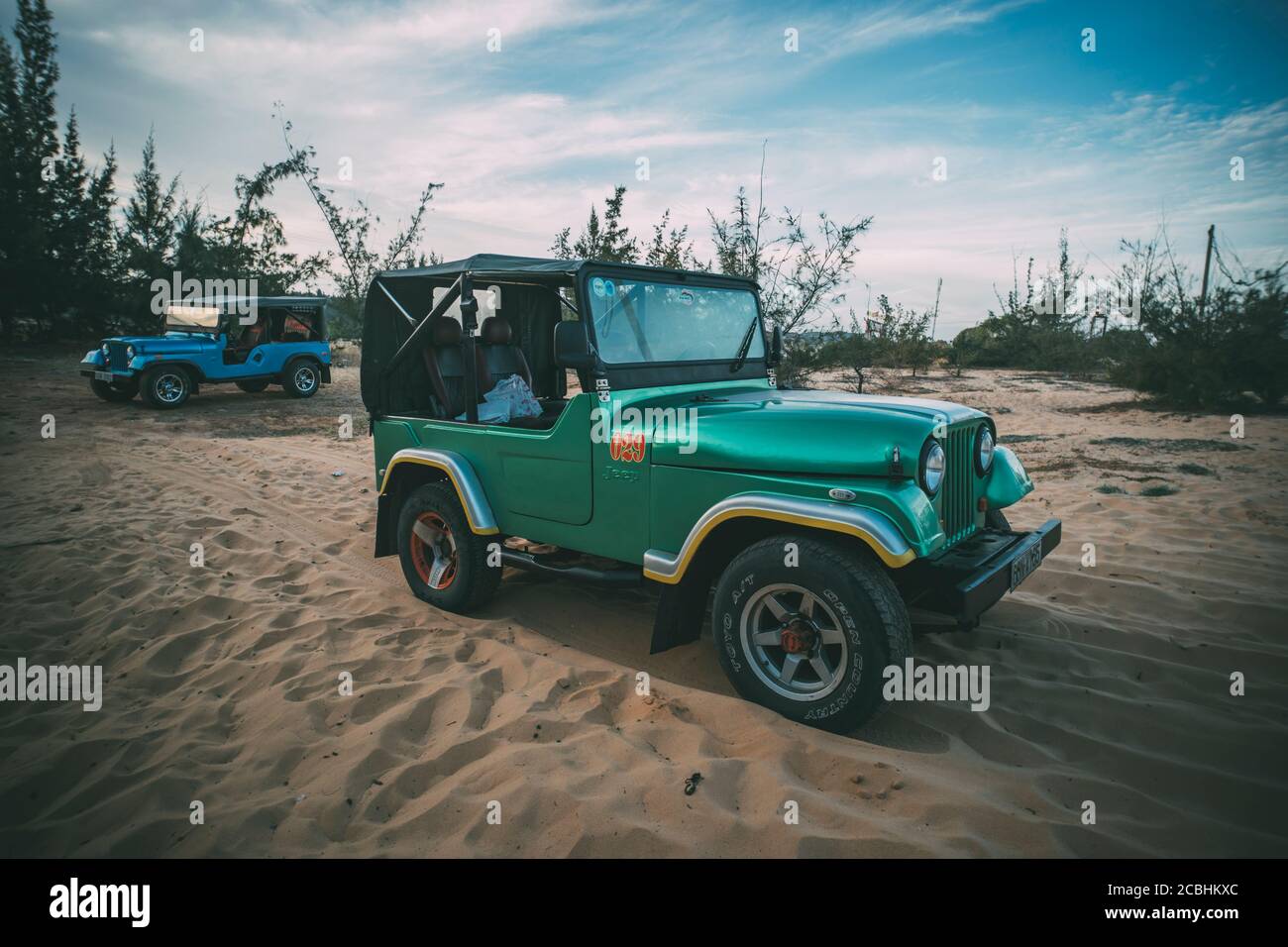 Voiture rétro restaurée pendant la guerre du Vietnam américain sur le sable dans le désert du Vietnam. Banque D'Images