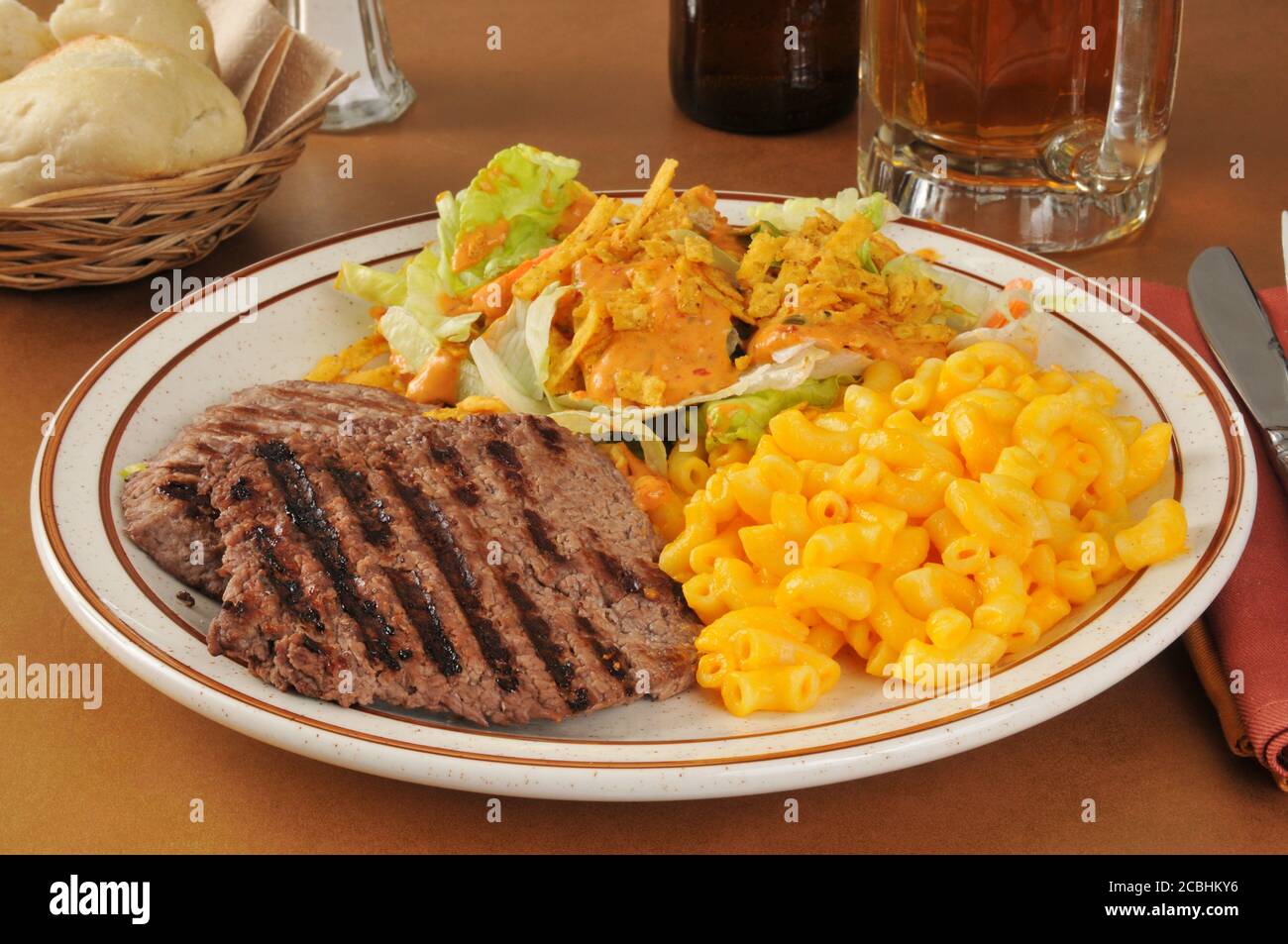 Un dîner de steak de cube avec macaroni au fromage et un salade Banque D'Images