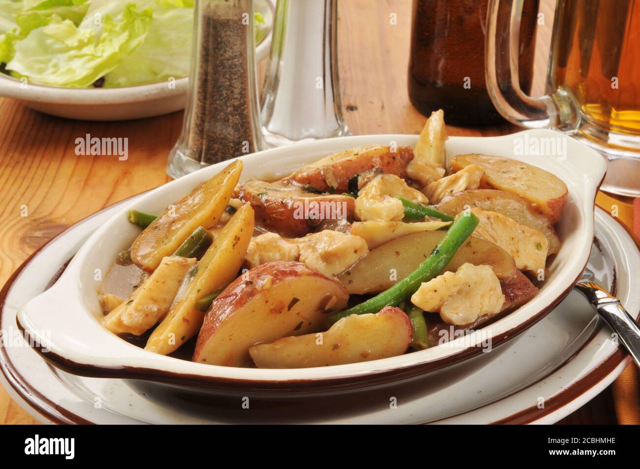 Une casserole de poulet et de pommes de terre à la peau rouge avec du vert haricots Banque D'Images