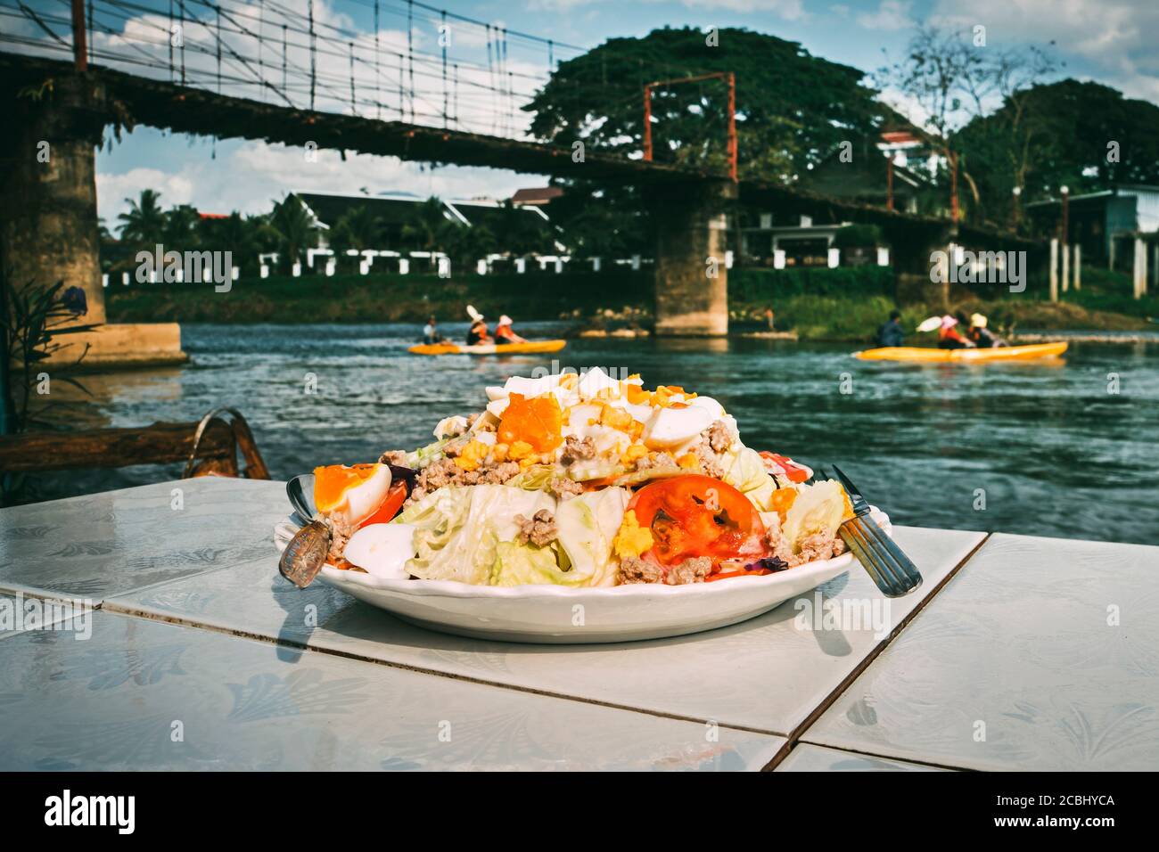 Nourriture de la cuisine nationale lao sur une plaque blanche La table dans le restaurant situé sur la Banque de La rivière Nam Song sur laquelle les touristes flottent sur un Banque D'Images
