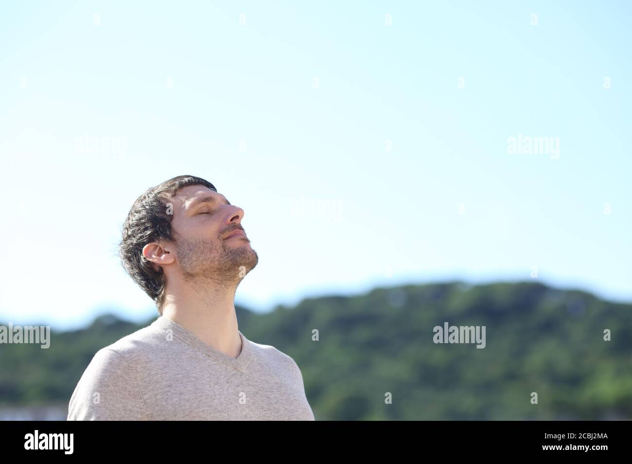 Homme respirant de l'air frais à l'extérieur, debout dans les montagnes ressort Banque D'Images