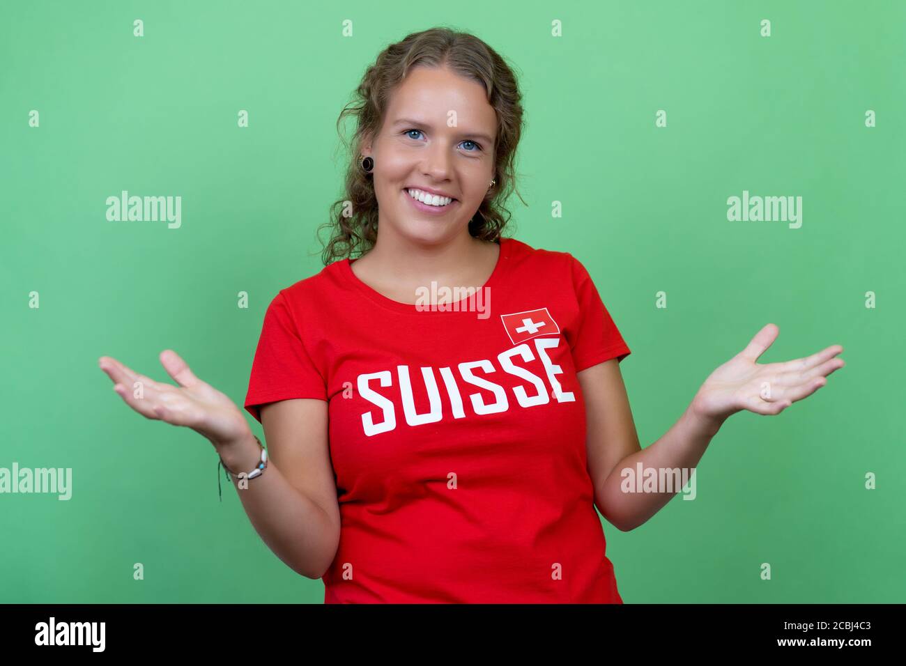 Femme blonde fan de football de Suisse isolée sur fond vert Banque D'Images