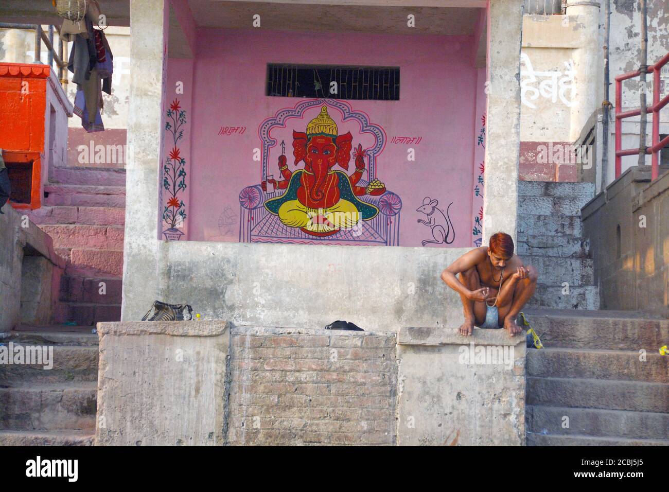 peinture murale ganesha et hommes locaux assis près du panch ganga ghat varanasi Banque D'Images