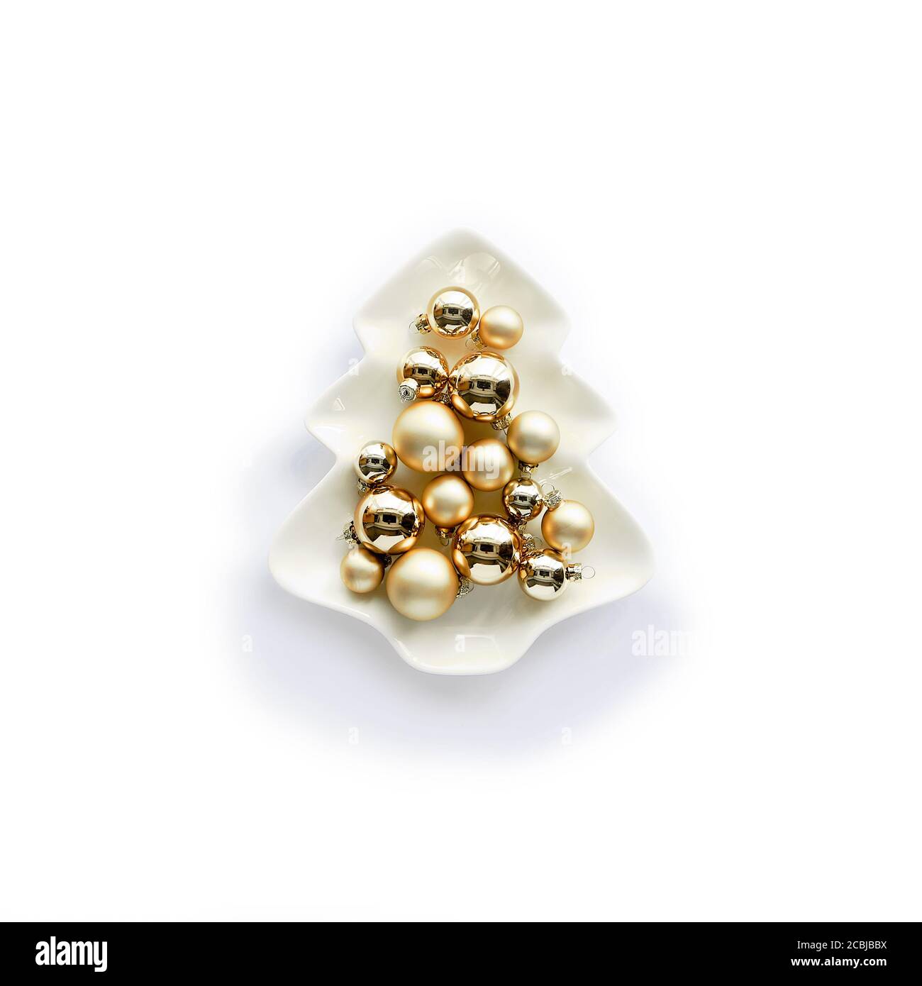 Breloques dorées, boules de Noël en céramique en forme d'arbre de Noël sur papier blanc. Design plat tendance et minimaliste pour les vacances d'hiver. Banque D'Images