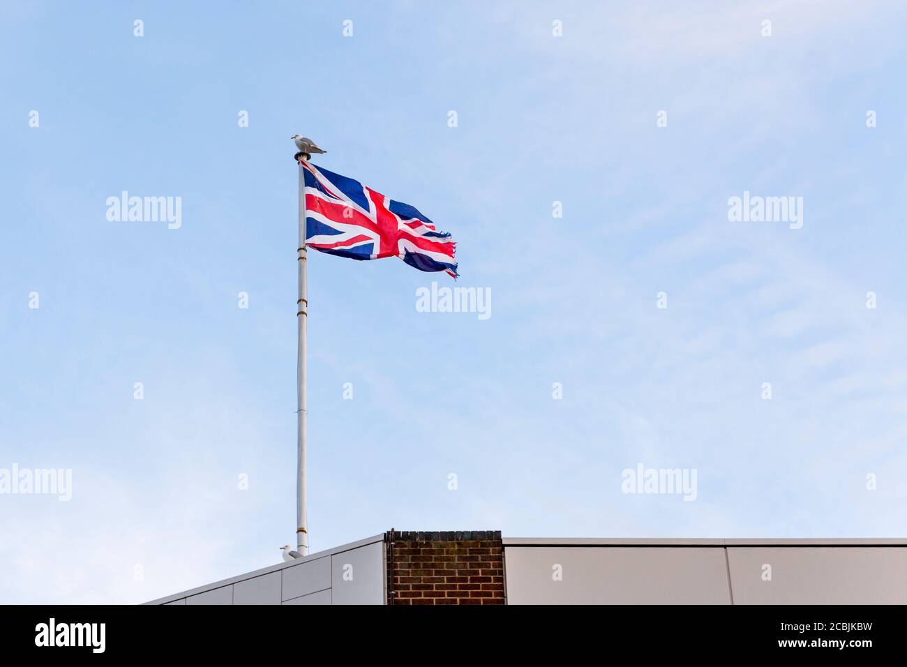 Drapeau du Royaume-Uni, drapeau d'Angleterre brodé sur le ciel bleu sur le toit d'un bâtiment. Banque D'Images